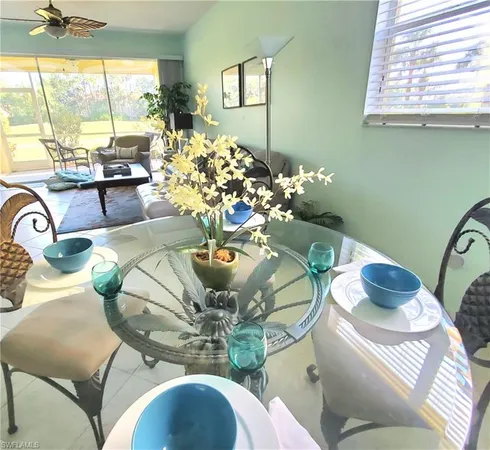 a view of a dining room with furniture a chandelier and large windows