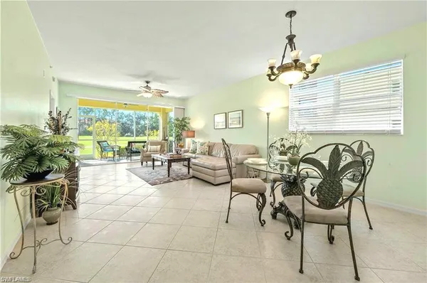 a living room with patio furniture and a large window