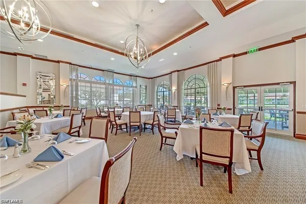 a living room with furniture chandelier and large windows