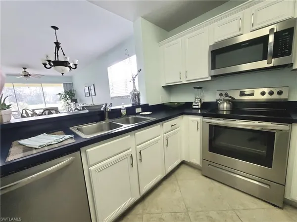 a kitchen with stainless steel appliances granite countertop a sink stove and microwave