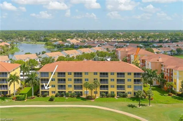 a view of a big building with a big yard and large trees