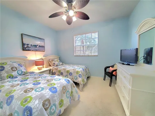 a bedroom with two beds and a chandelier