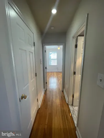 a view of a hallway with wooden floor