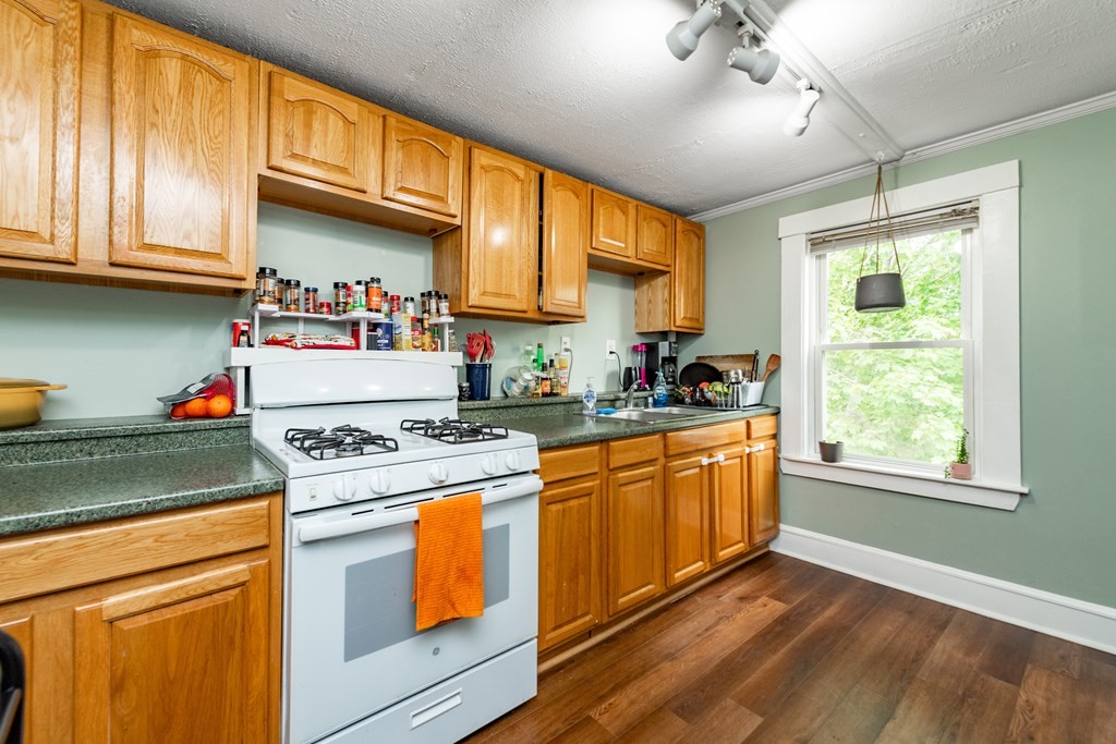 28 Walnut Street Natick, MA 01760 - Photo 11 of 24 a kitchen with stainless steel appliances granite countertop a stove a sink and a refrigerator