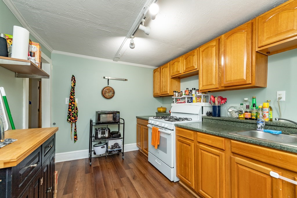 28 Walnut Street Natick, MA 01760 - Photo 12 of 24 a kitchen with stainless steel appliances granite countertop a stove a sink dishwasher and cabinets with wooden floor