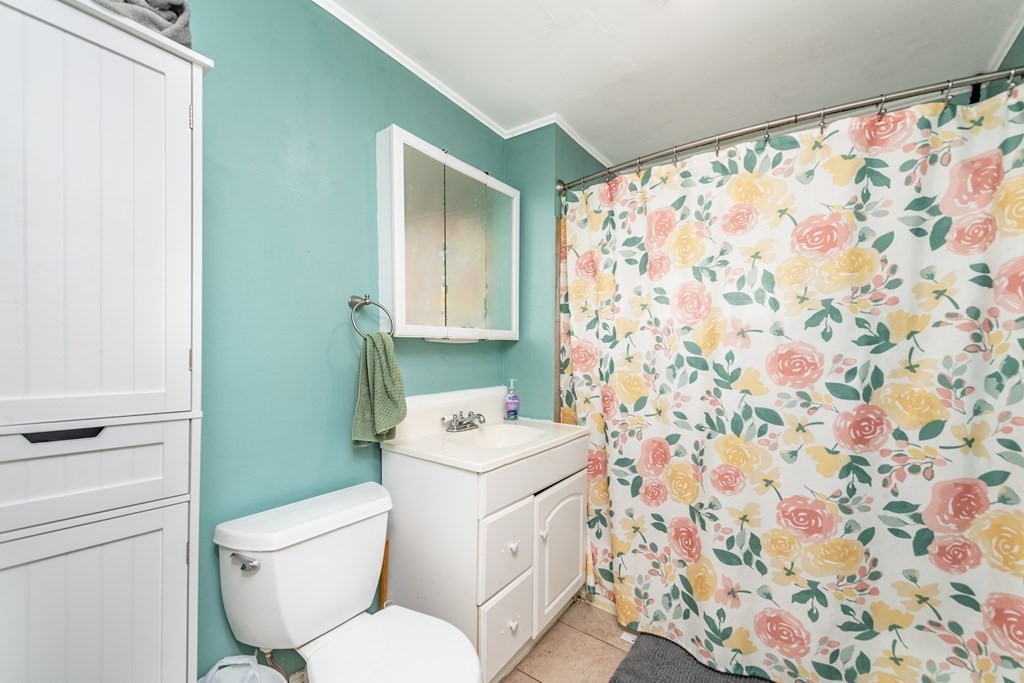 28 Walnut Street Natick, MA 01760 - Photo 13 of 24 a white toilet sitting next to a shower curtain