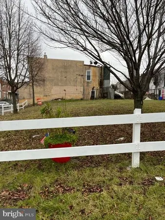 a front view of a house with a large tree