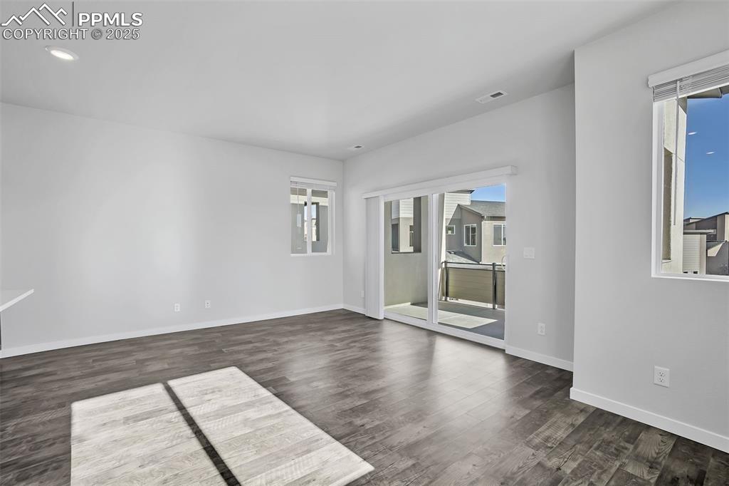 13605 Frost Bitten Grove Colorado Springs, CO 80921 - Photo 16 of 23 an empty room with wooden floor and windows