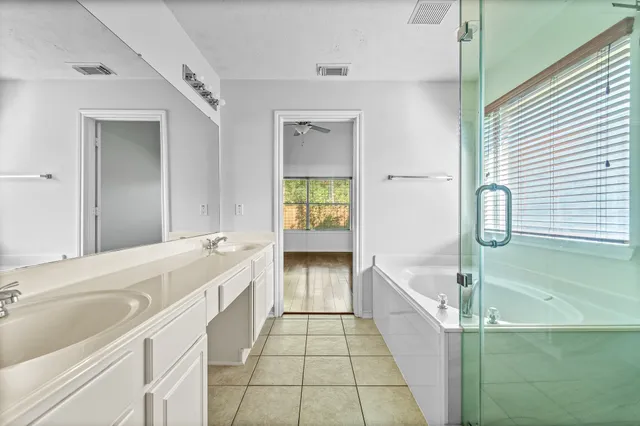 a bathroom with a tub sink and mirror