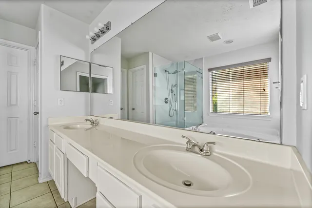 a bathroom with double vanity sinks and a bathtub