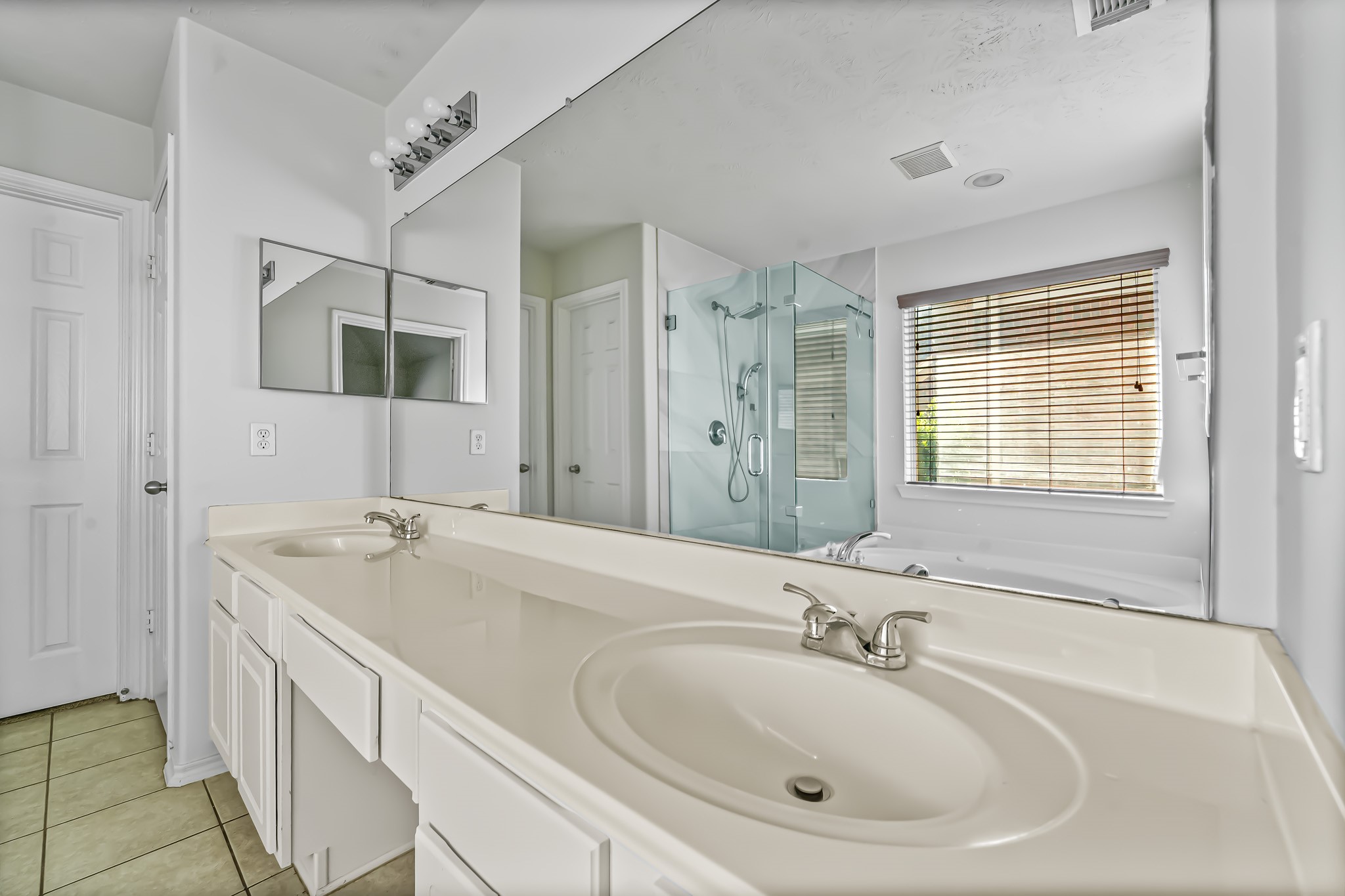 16210 Bloom Meadow Trail Cypress, TX 77433 - Photo 18 of 32 a bathroom with double vanity sinks and a bathtub