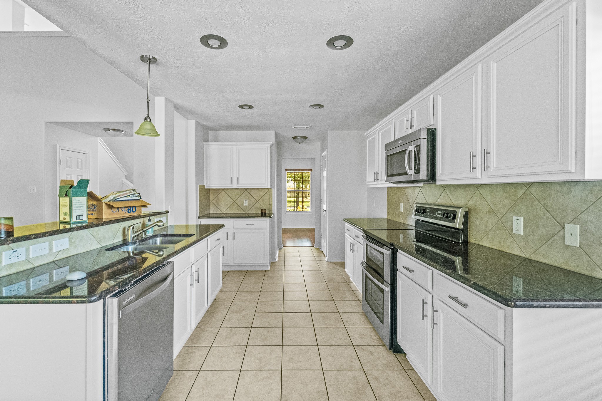 16210 Bloom Meadow Trail Cypress, TX 77433 - Photo 8 of 32 a large kitchen with stainless steel appliances granite countertop a stove and a sink