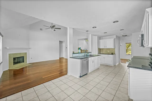 a kitchen with granite countertop a refrigerator and a stove top oven