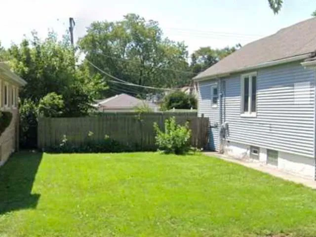 a backyard of a house with a garden and plants