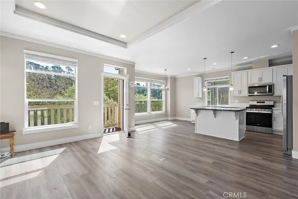 a view of kitchen with granite countertop a stove top oven a sink and a large window