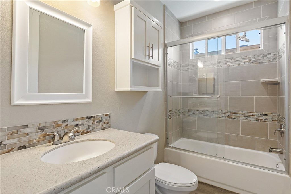 1460 Main Street, Unit 112 Cambria, CA 93428 - Photo 14 of 19 a bathroom with a granite countertop sink toilet and shower