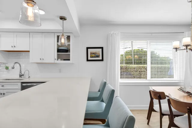 a large white kitchen with a large window