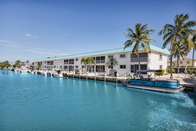 a group of people sitting on a pier next to a lake