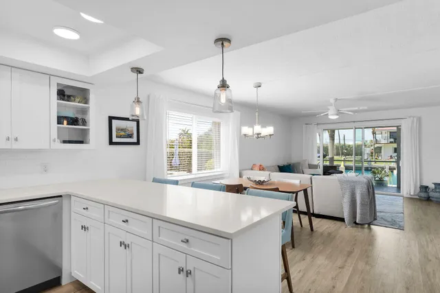 a large kitchen with kitchen island a large window a sink a counter space and stainless steel appliances