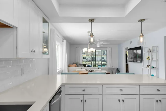 a view of a kitchen with kitchen island a counter top space appliances and cabinets