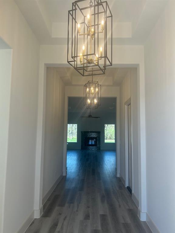 415 East Burks Street Pilot Point, TX 76258 - Photo 4 of 13 a view of a hallway with wooden floor and a chandelier