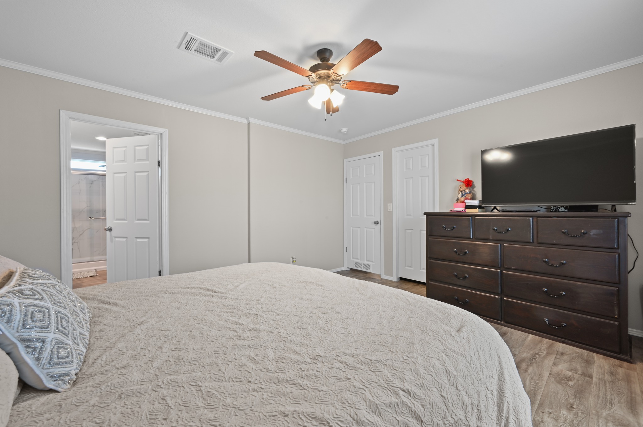 117 Castellana Way Elgin, TX 78621 - Photo 13 of 28 Bedroom featuring ornamental molding, ceiling fan, light wood-type flooring, and ensuite bath