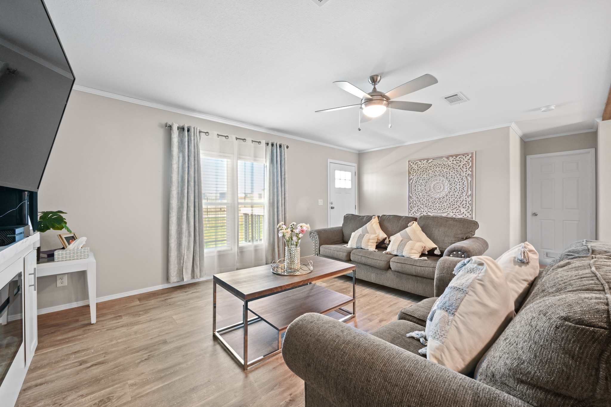 117 Castellana Way Elgin, TX 78621 - Photo 6 of 28 Living room featuring light wood finished floors, ornamental molding, and ceiling fan