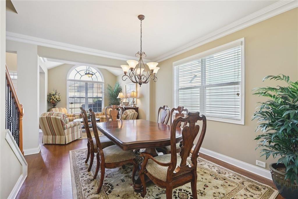 4460 Granby Circle Cumming, GA 30041 - Photo 12 of 34 a dining room with furniture potted plants and wooden floor
