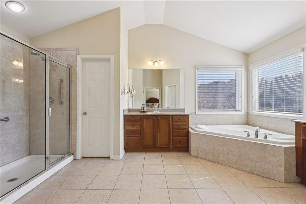 4460 Granby Circle Cumming, GA 30041 - Photo 17 of 34 a bathroom with a tub a sink and a large mirror