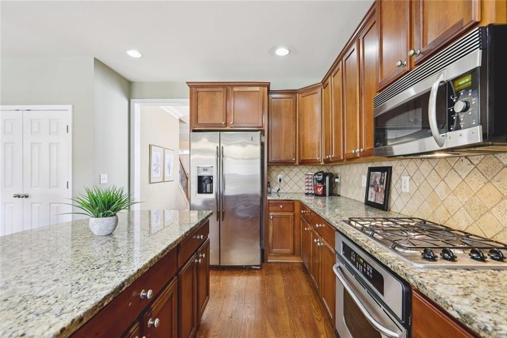 4460 Granby Circle Cumming, GA 30041 - Photo 5 of 34 a kitchen with stainless steel appliances granite countertop a stove a sink dishwasher and a refrigerator