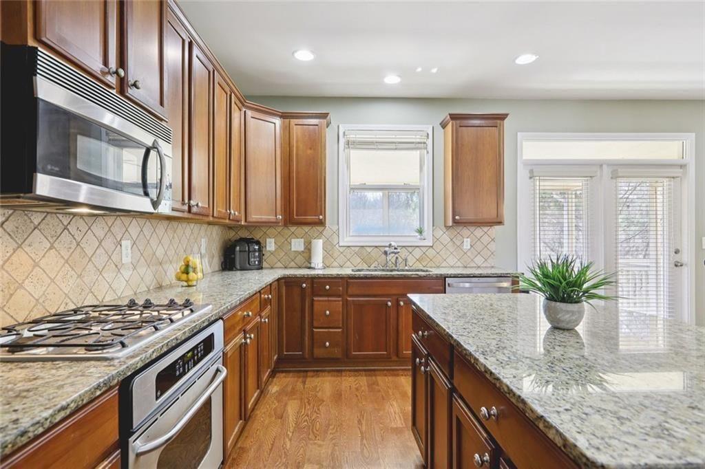 4460 Granby Circle Cumming, GA 30041 - Photo 6 of 34 a kitchen with a sink stove and cabinets