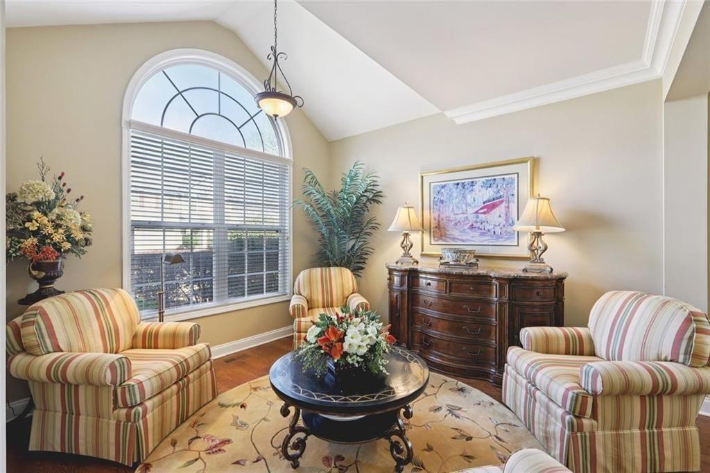 4460 Granby Circle Cumming, GA 30041 - Photo 10 of 34 a living room with furniture a chandelier and a fireplace