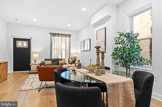 a living room with stainless steel appliances furniture a couch and a kitchen view