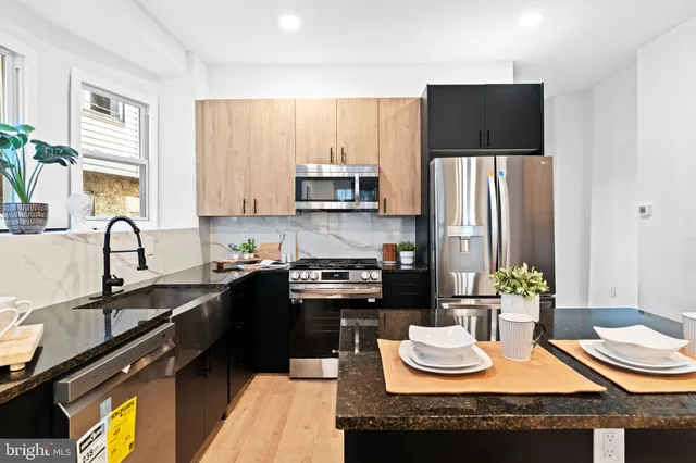 a kitchen with a refrigerator a stove a sink and a dining table