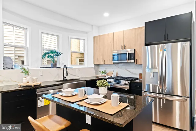 a kitchen with a refrigerator stove top oven and sink