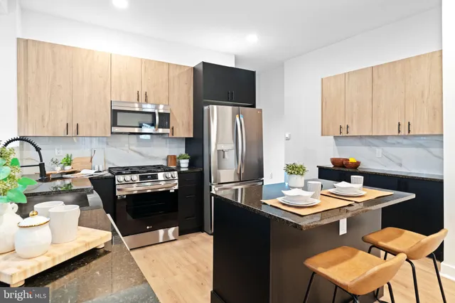 a kitchen with stainless steel appliances a sink a stove a microwave a sink and cabinets