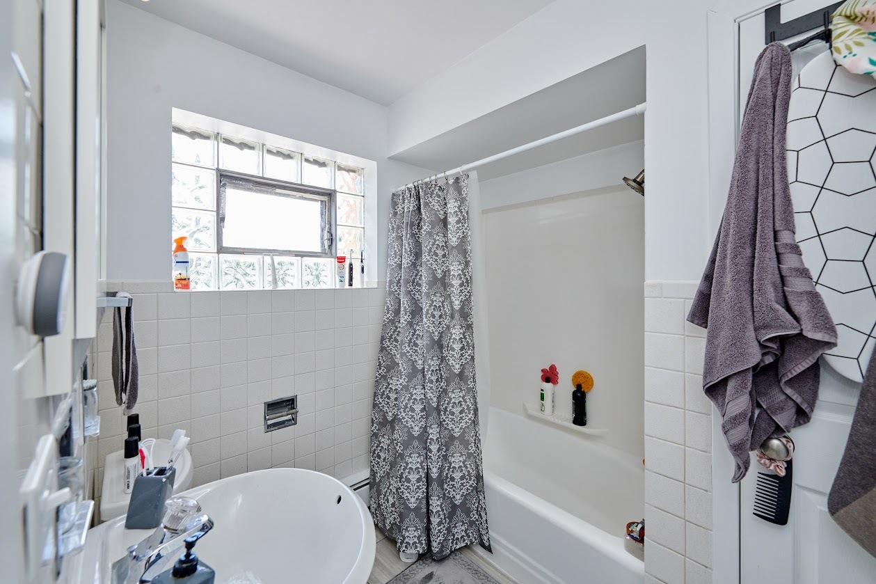 8211 West Irving Park Road Chicago, IL 60634 - Photo 17 of 28 a bathroom with a bathtub a sink and a toilet