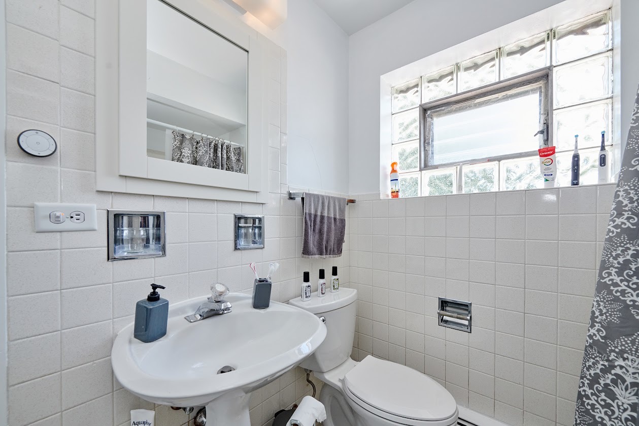 8211 West Irving Park Road Chicago, IL 60634 - Photo 18 of 28 a bathroom with a toilet sink and mirror