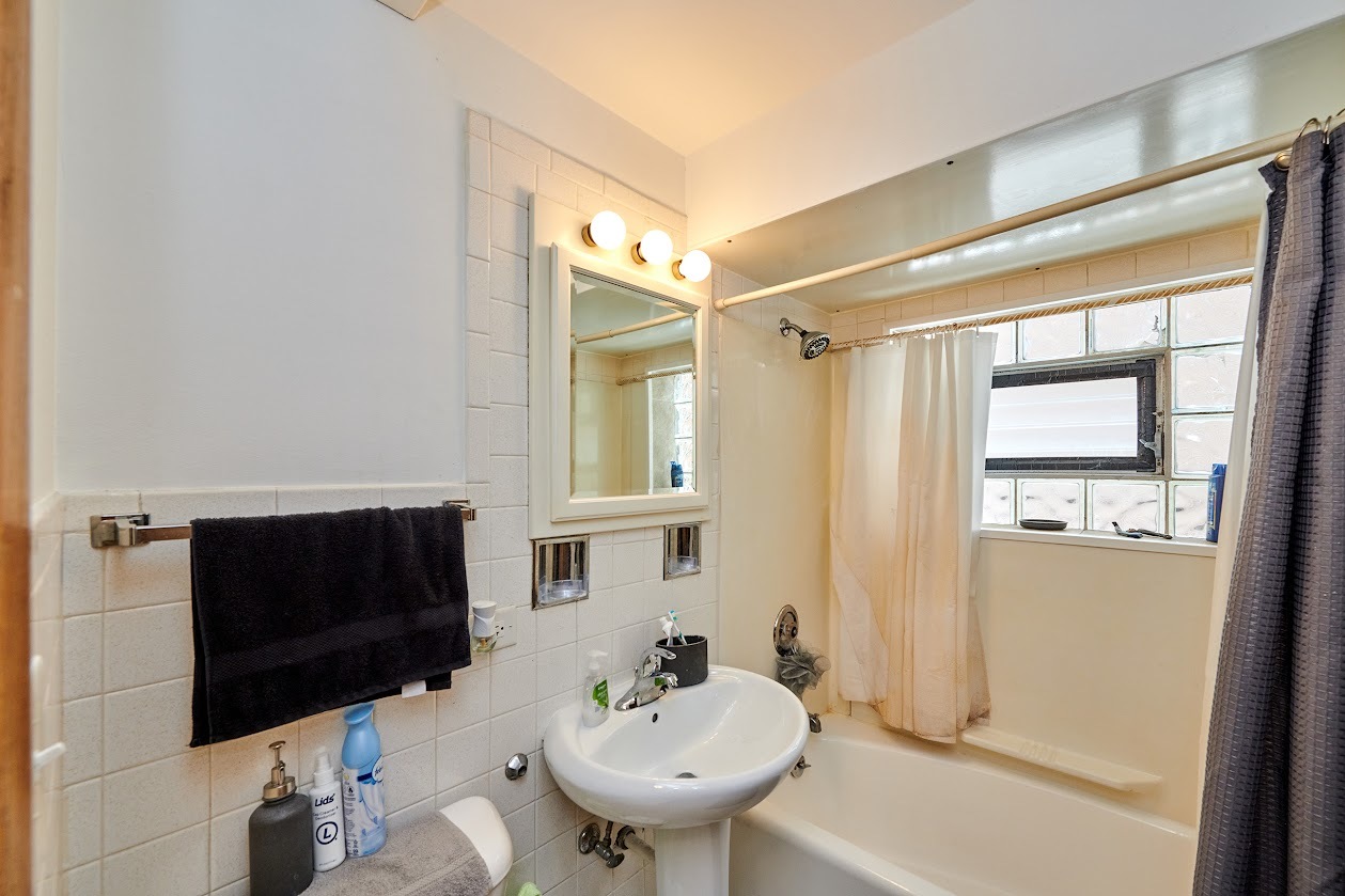 8211 West Irving Park Road Chicago, IL 60634 - Photo 23 of 28 a bathroom with a sink a toilet and shower