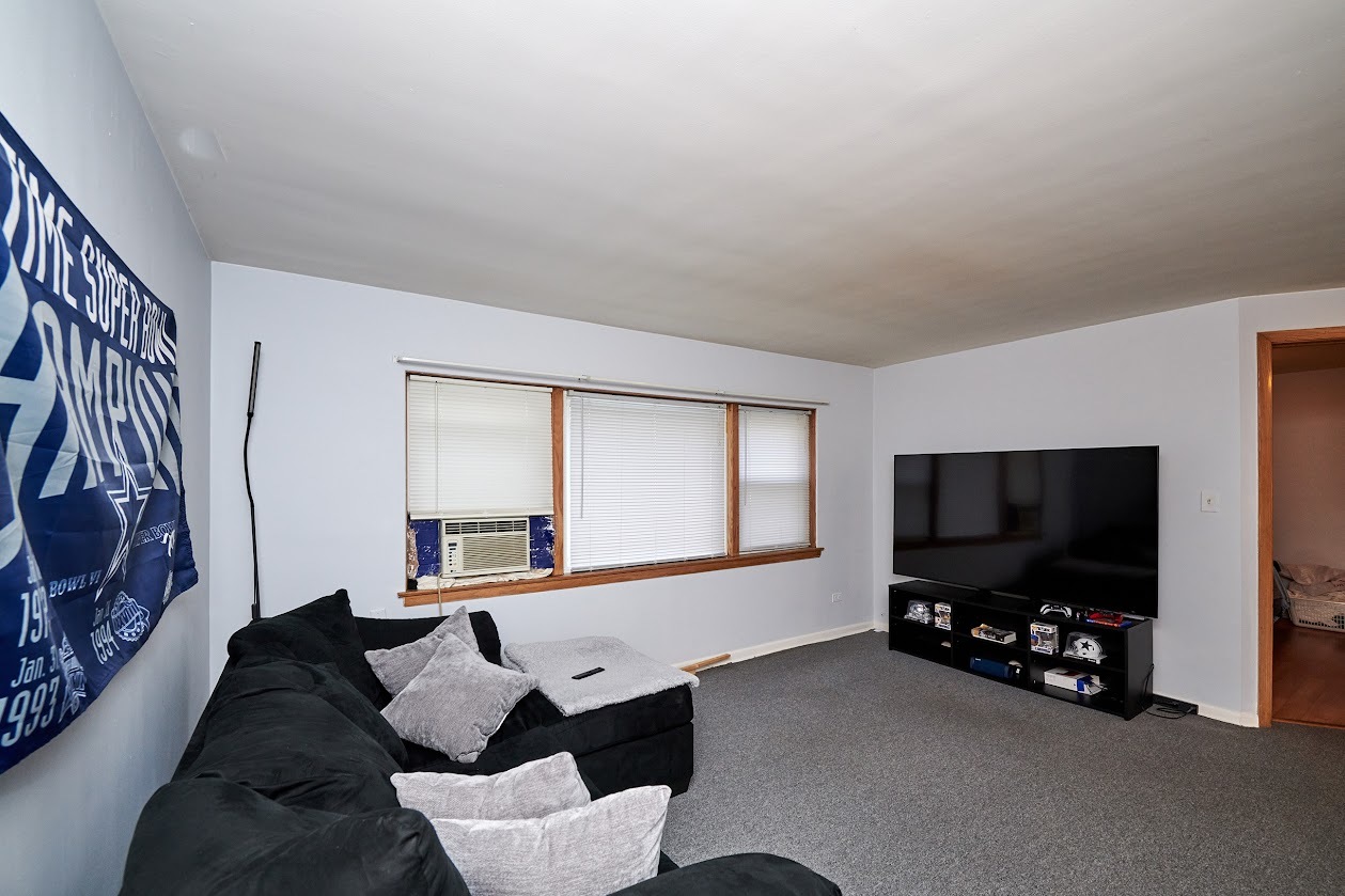 8211 West Irving Park Road Chicago, IL 60634 - Photo 24 of 28 a living room with furniture and a flat screen tv