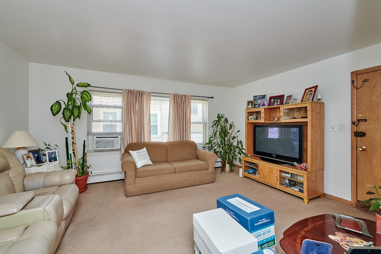 8211 West Irving Park Road Chicago, IL 60634 - Photo 3 of 28 a living room with furniture and a flat screen tv