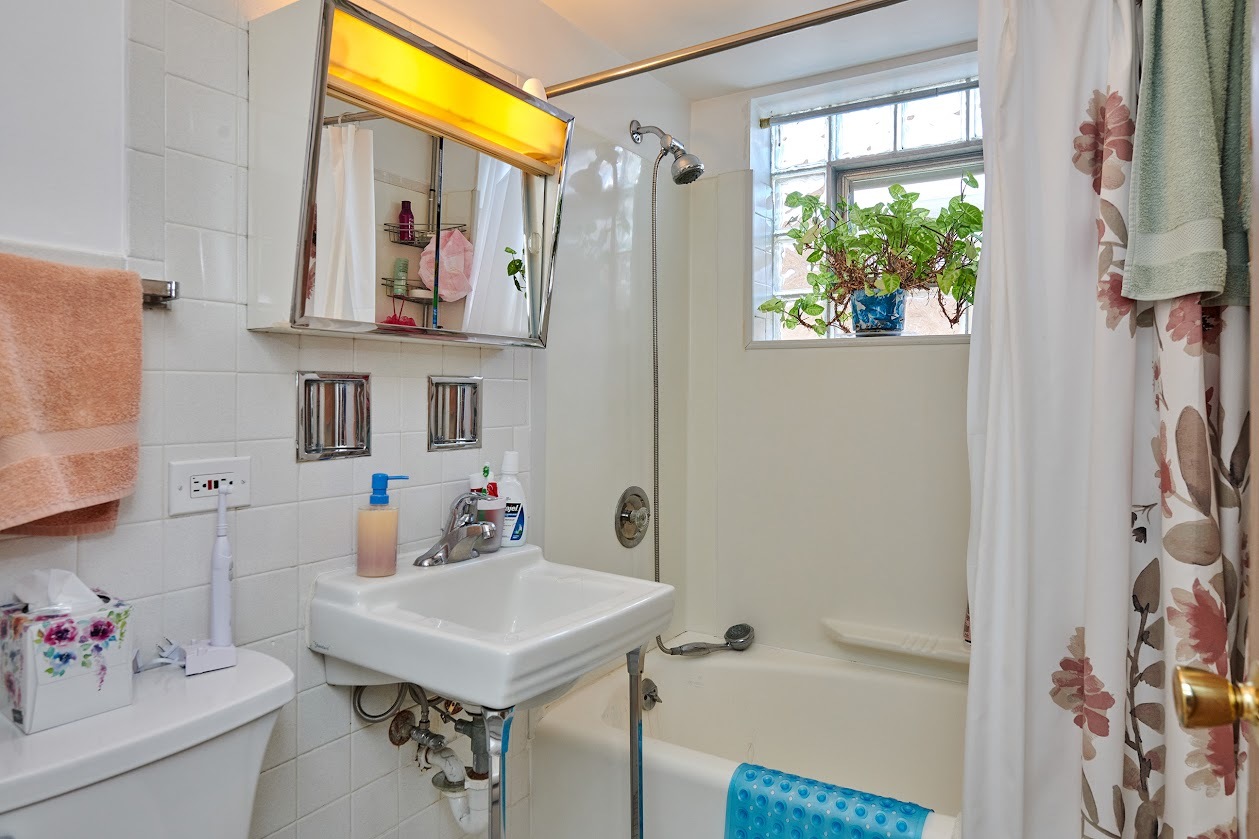8211 West Irving Park Road Chicago, IL 60634 - Photo 5 of 28 a bathroom with a sink mirror and a bathtub