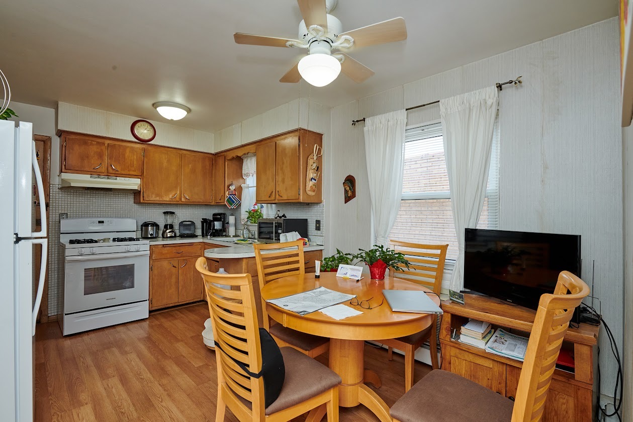 8211 West Irving Park Road Chicago, IL 60634 - Photo 8 of 28 a kitchen with stainless steel appliances granite countertop a stove a refrigerator a kitchen island a dining table and chairs