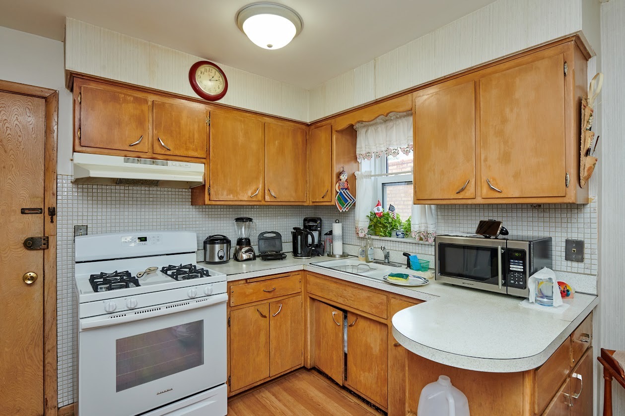 8211 West Irving Park Road Chicago, IL 60634 - Photo 9 of 28 a kitchen with stainless steel appliances granite countertop a stove a sink and a microwave