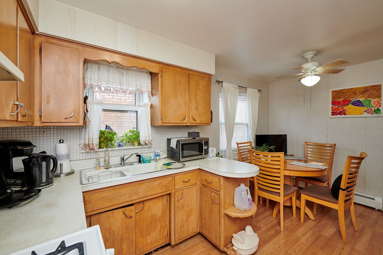 8211 West Irving Park Road Chicago, IL 60634 - Photo 10 of 28 a kitchen with a table chairs stove and cabinets