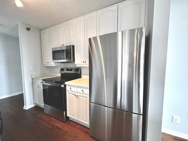 a kitchen with stainless steel appliances a refrigerator a stove top oven a sink and dishwasher
