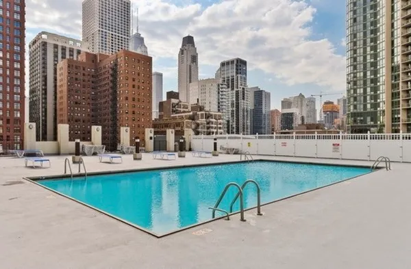 a view of swimming pool with outdoor seating and city view