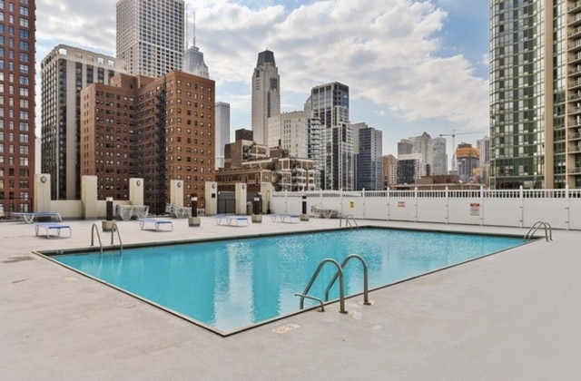 1122 North Clark Street, Unit 2806 Chicago, IL 60610 - Photo 19 of 20 a view of swimming pool with outdoor seating and city view