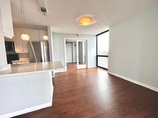 a view of a big room with wooden floor and windows