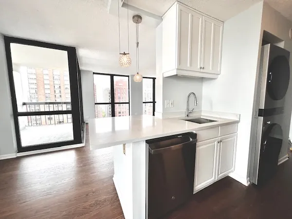 a kitchen with stainless steel appliances granite countertop a sink a stove and a wooden floors